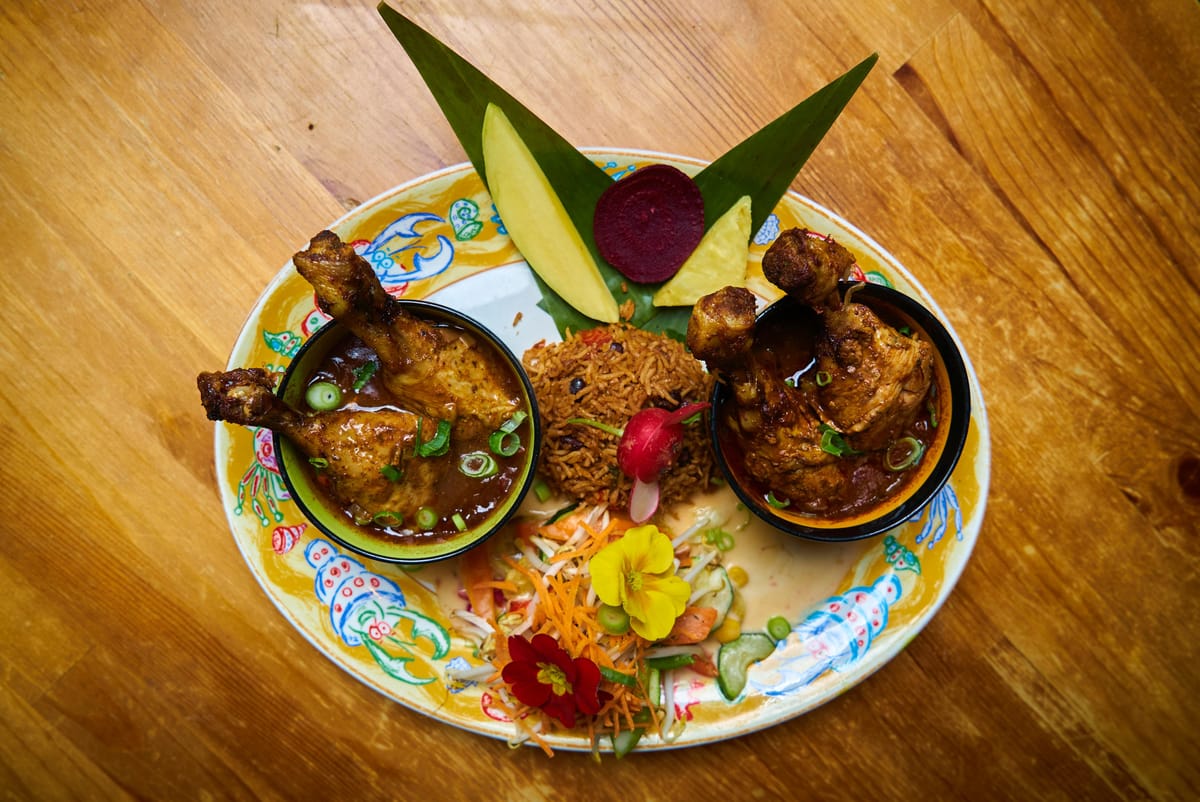 Jamaican Jerk Chicken auf Bananenblatt mit Reis und Salat