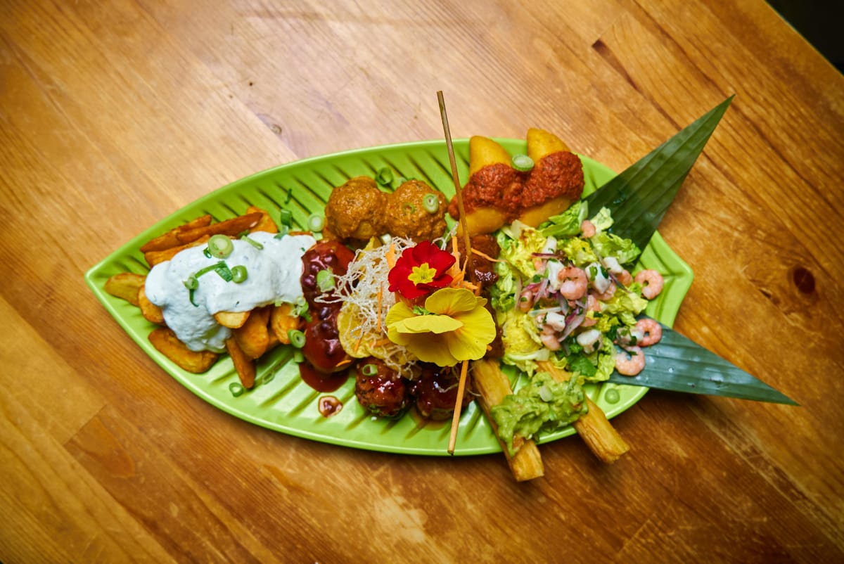 Platte mit Fischfilet, Muschel und Kochbananen auf Bananenblatt
