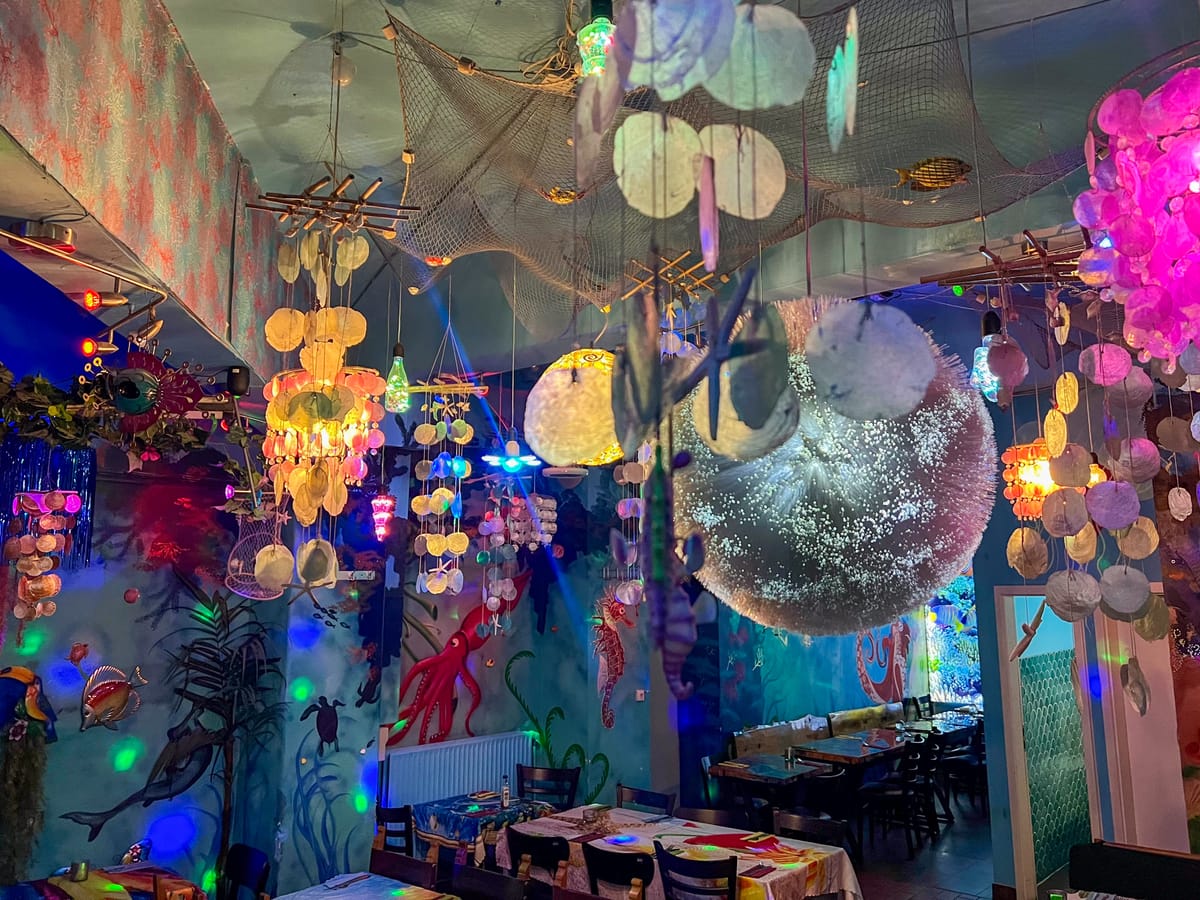Bunte Lampen, Spiegelkugel und Muschelvorhang im Gastraum